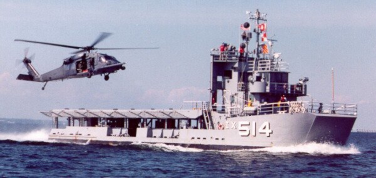 a helicopter is flying over a ship in the water.	