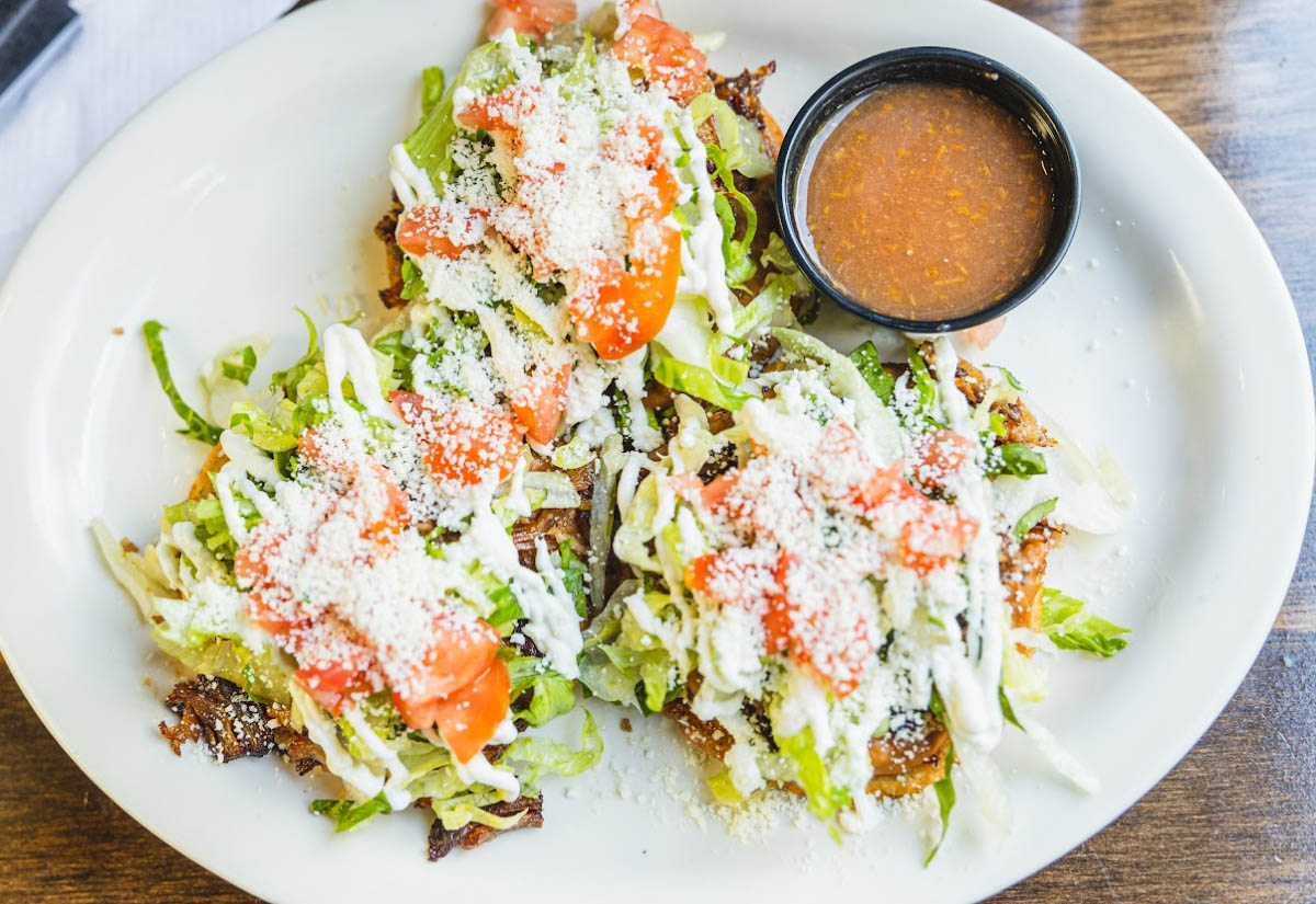 Salad, with lettuce, tomato, sprinkled cheese, and dressing