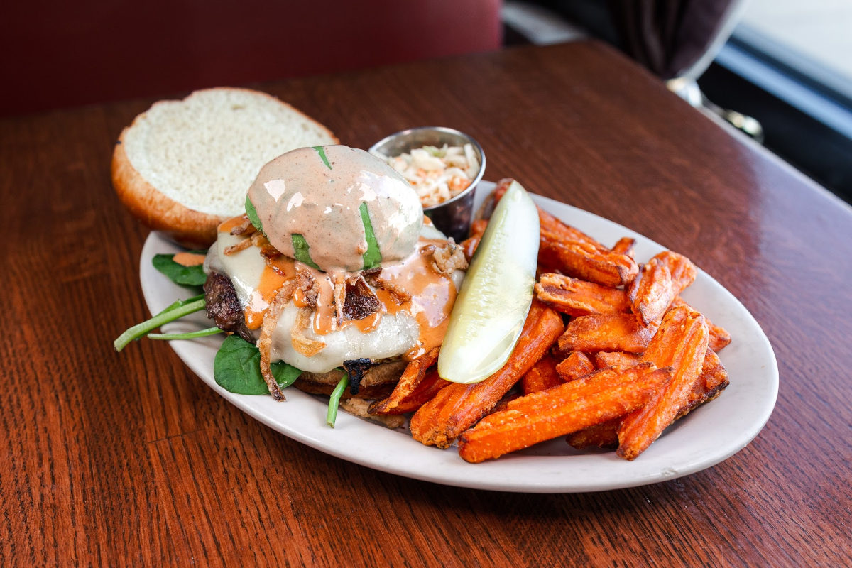 Grilled chicken sandwich with cheese, sweet potato fries, and nuts.