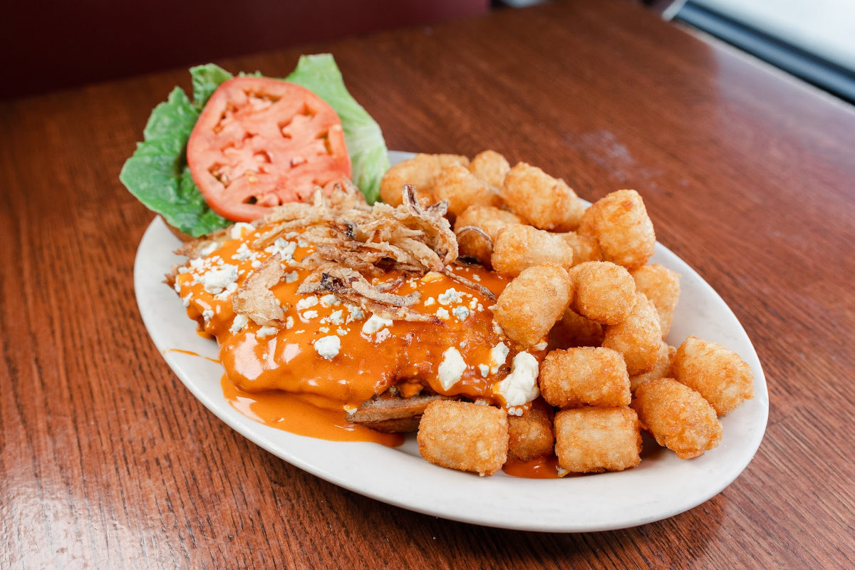 Buffalo chicken with crumbled cheese and fried onion strings, served with tater tots.