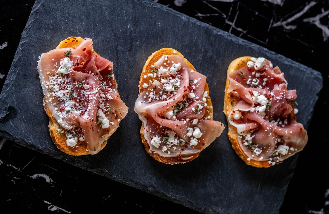 Top view of three fig and prosciutto sandwiches