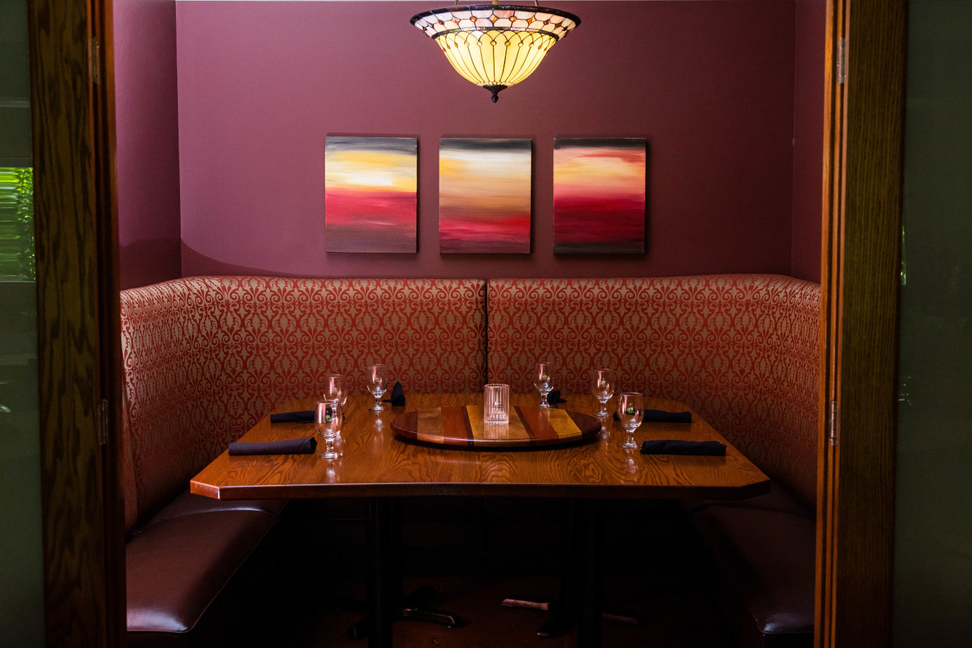 Interior, booth with set table, artwork on the wall