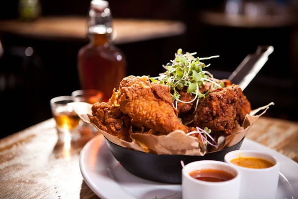 A bowl of fried chicken on a wooden table
