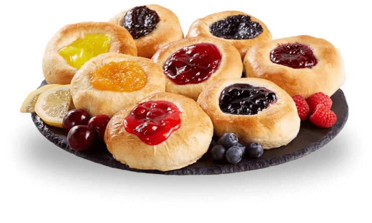 A plate filled with assorted kolaches topped with fresh fruit and vibrant berries.