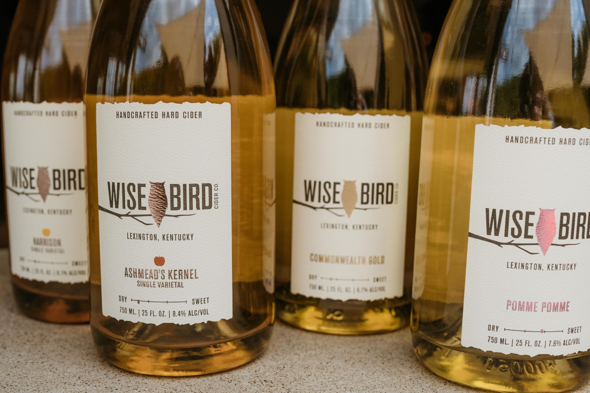 Five bottles of wine with the label 'Wise Bird' displayed on a wooden table, ready to be enjoyed.