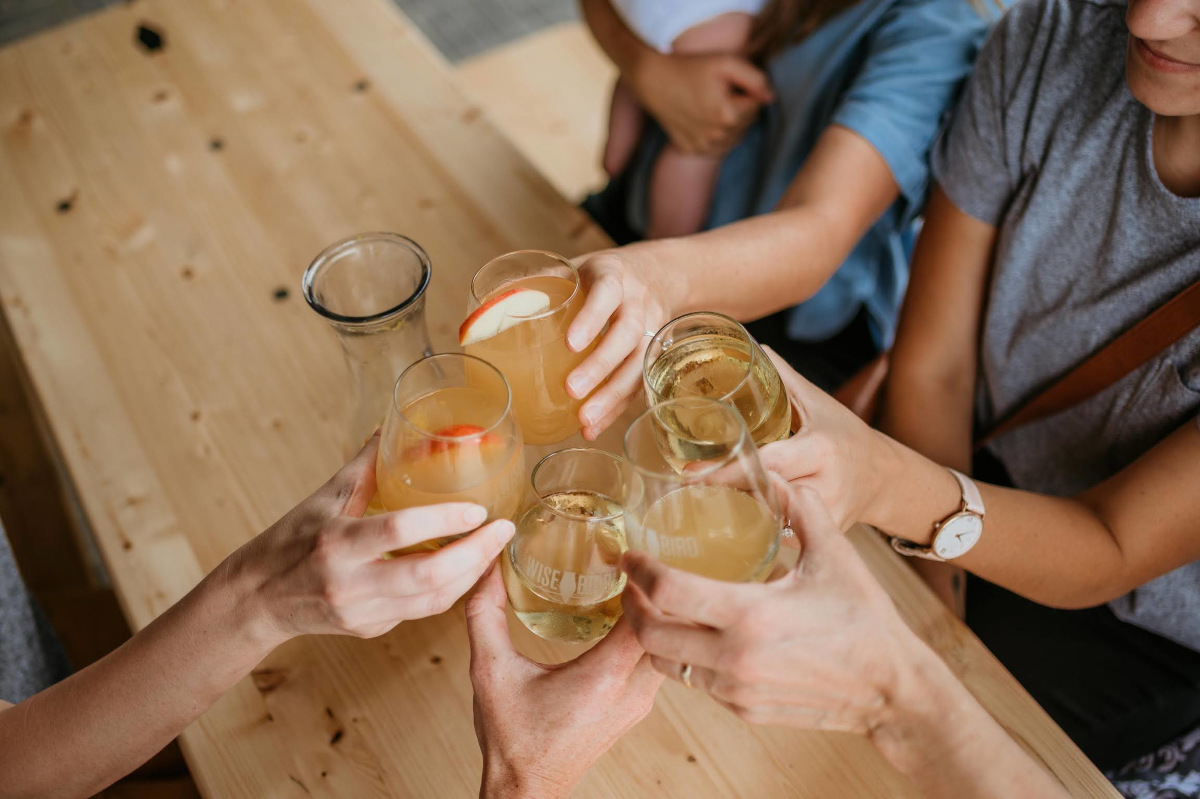 A joyful gathering of people raising wine glasses in celebration.