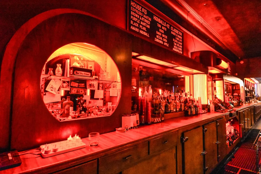 A bar with red lights illuminating the space