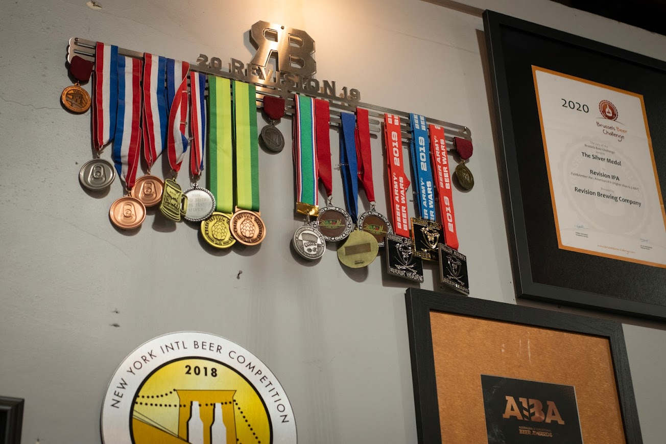 A wall of medals and plaques on a wall.