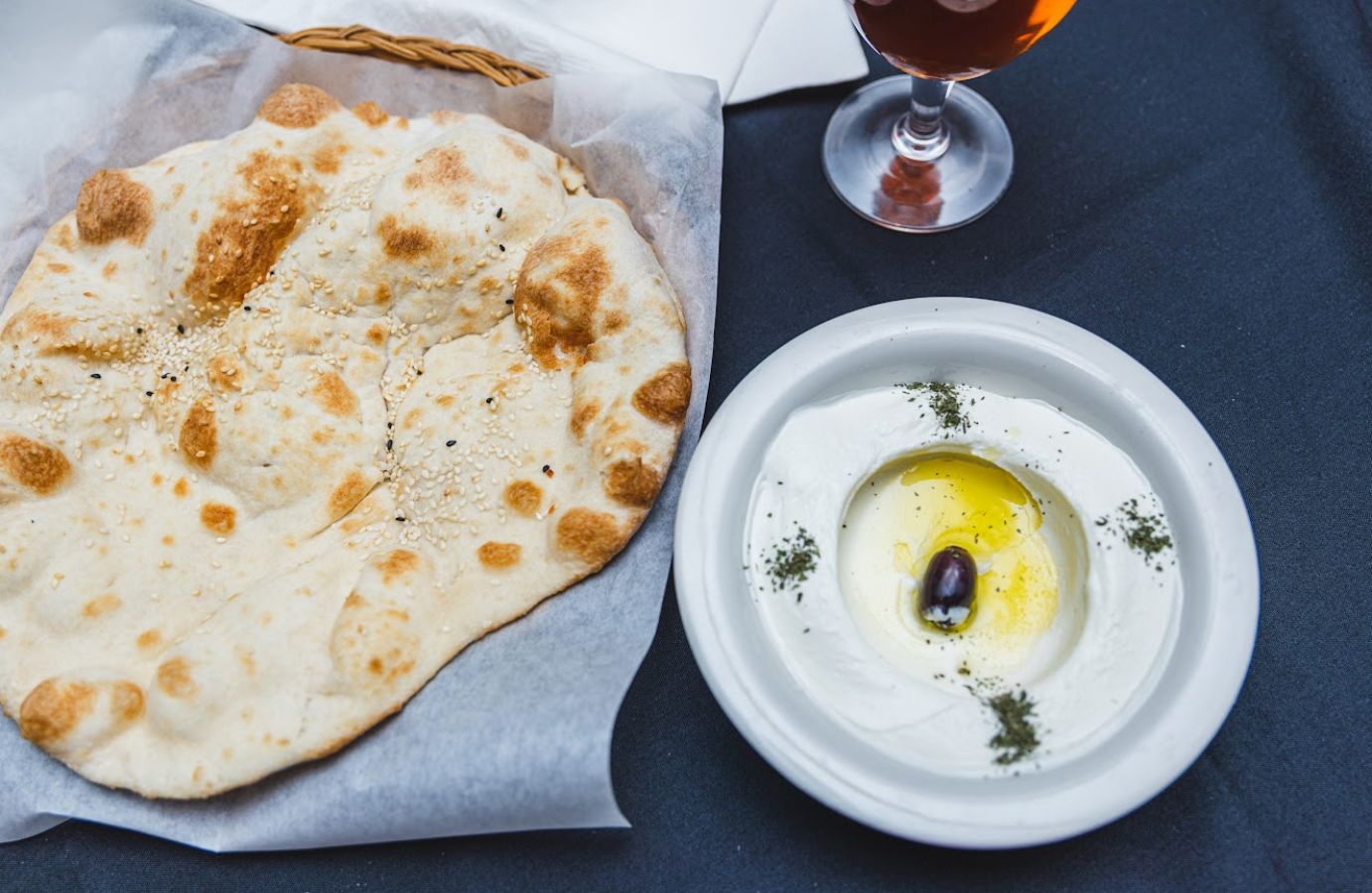 Top view of a Lebanese pita bread and a bowl of dipping sauce