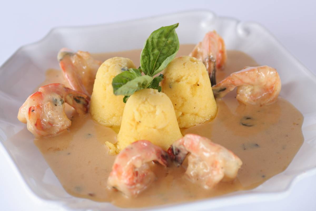 Creamy polenta with shrimp and basil garnish.