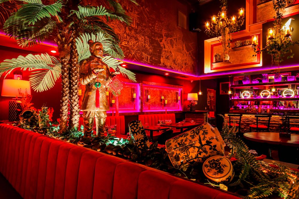 A bar with a palm tree and red lights.
