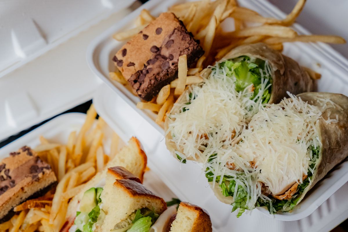 Catering boxes with wraps, sandwiches, fries and brownies