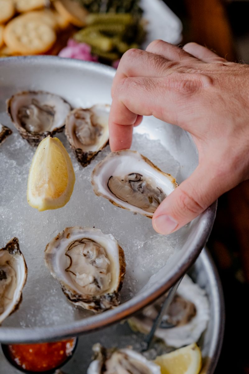 Freshly shucked oysters on ice with lemon wedges