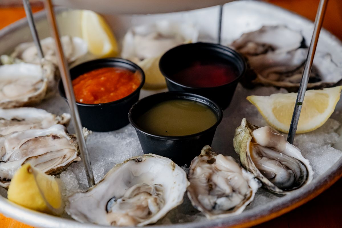 Oysters on ice with cocktail sauce, mignonette and lemon