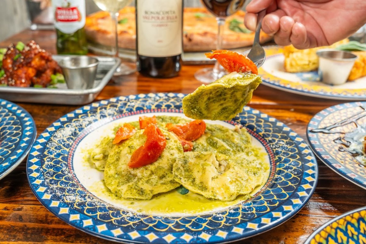 A person eating ravioli served on a plate