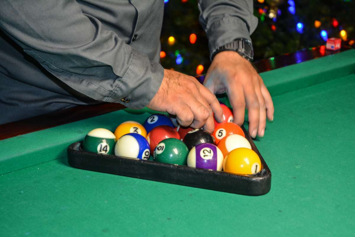 Arranging billiard balls on table using a rack, close -up