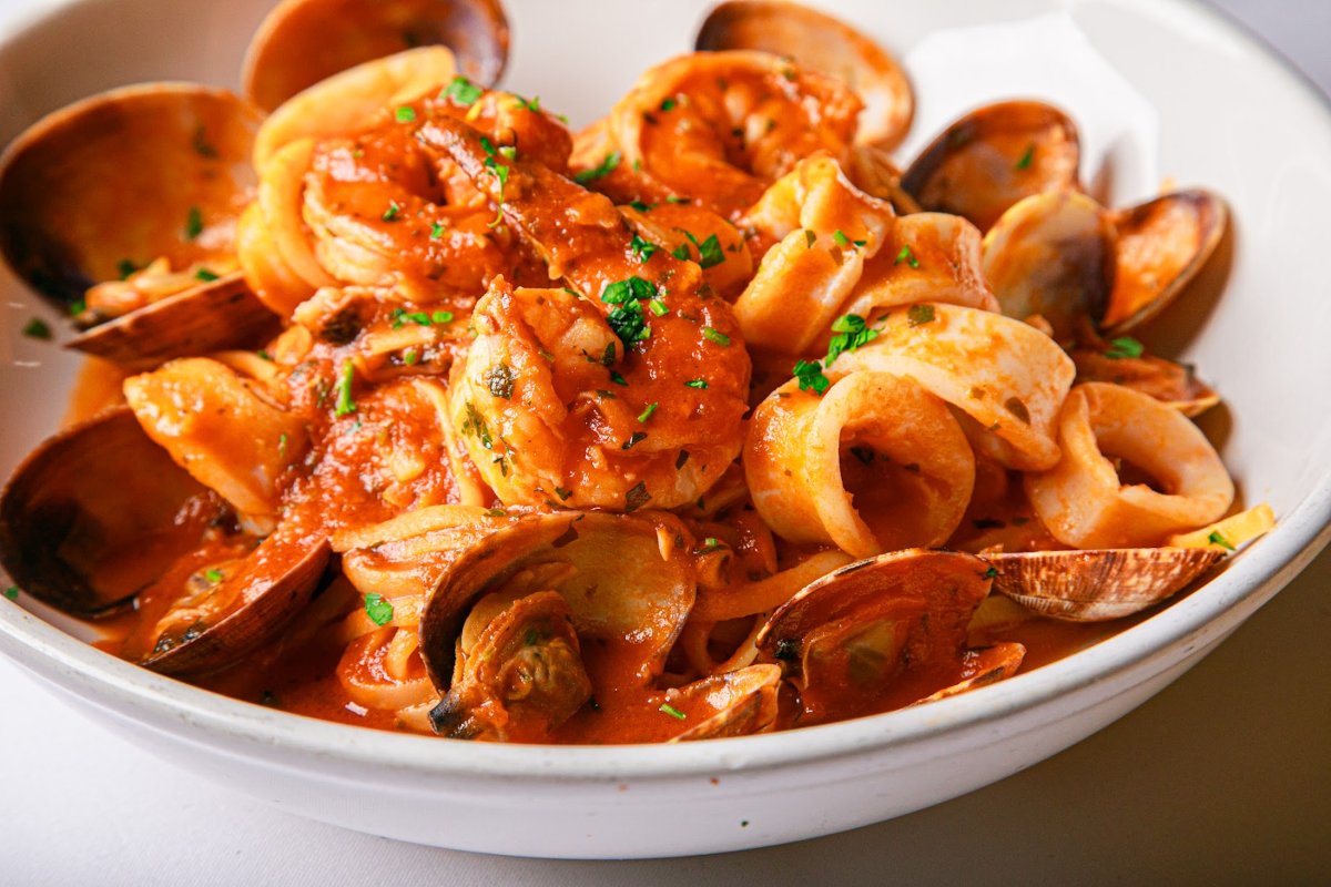 a bowl of pasta with seafood and sauce