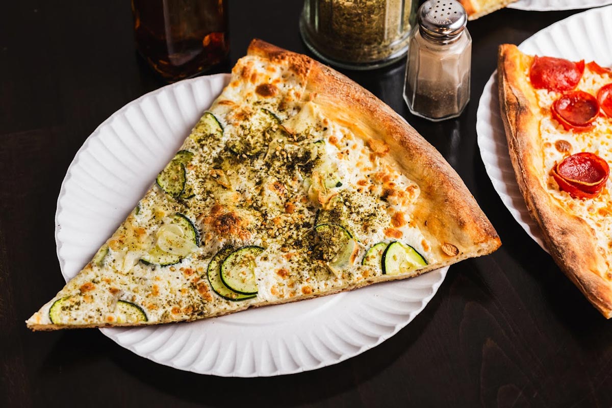 A slice of a skinny zucchini pizza served