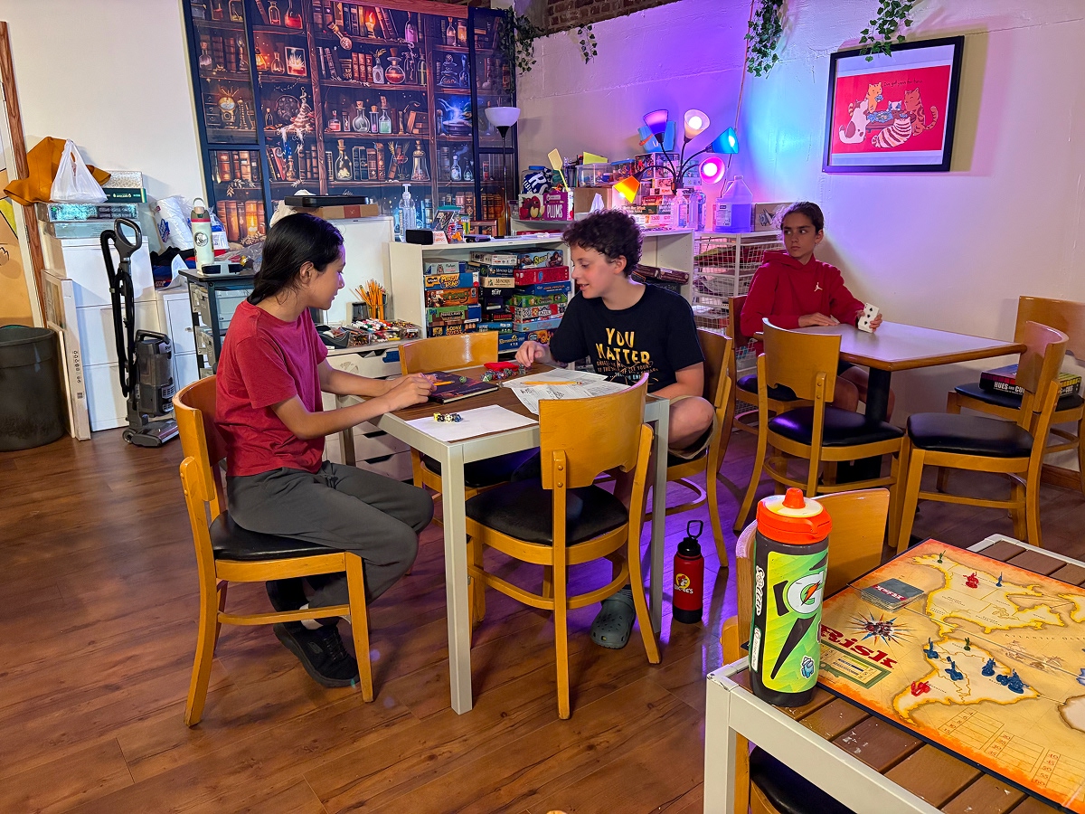 A group of children engrossed in a board game, showcasing their strategic skills.