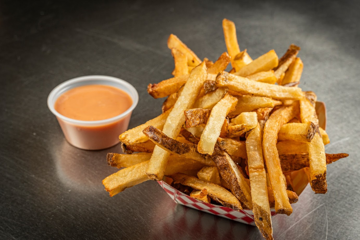 French fries in a basket with a tangy dipping sauce