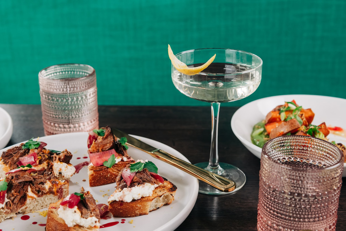 A table with plates of food and a glass of wine.