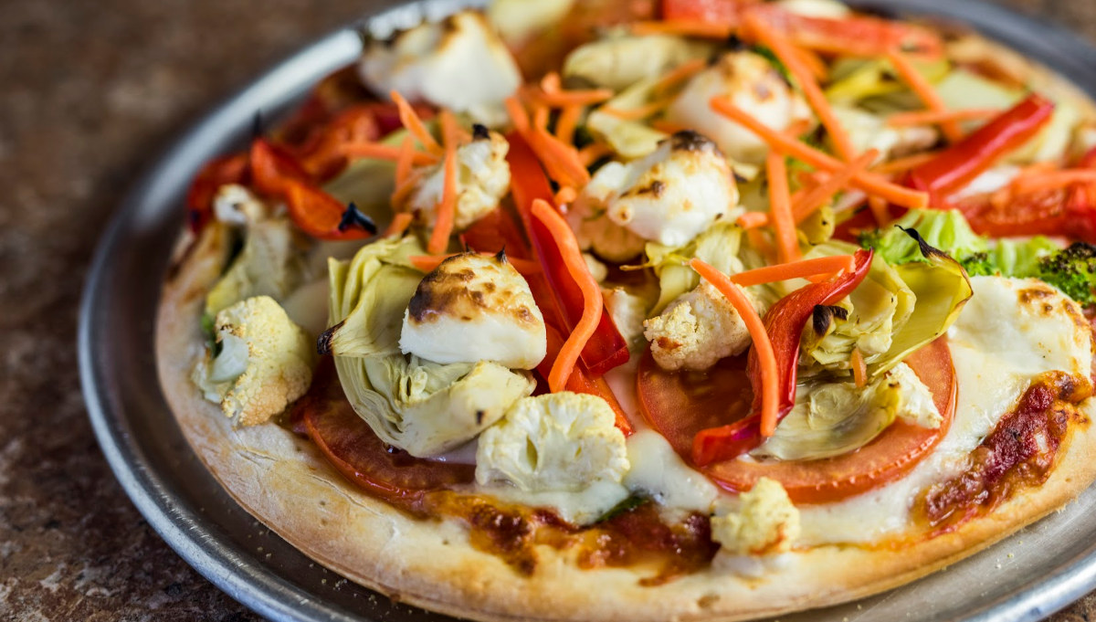 A delicious pizza topped with a colorful assortment of fresh vegetables.