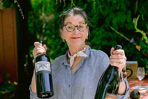 a person holding two bottles of wine