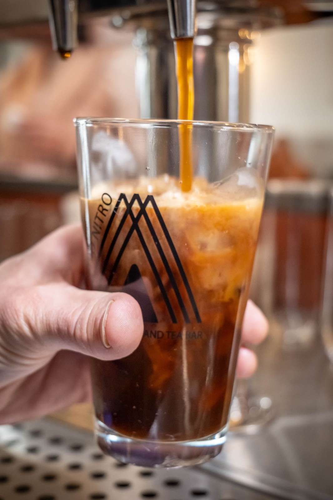 a hand holding a glass of coffee