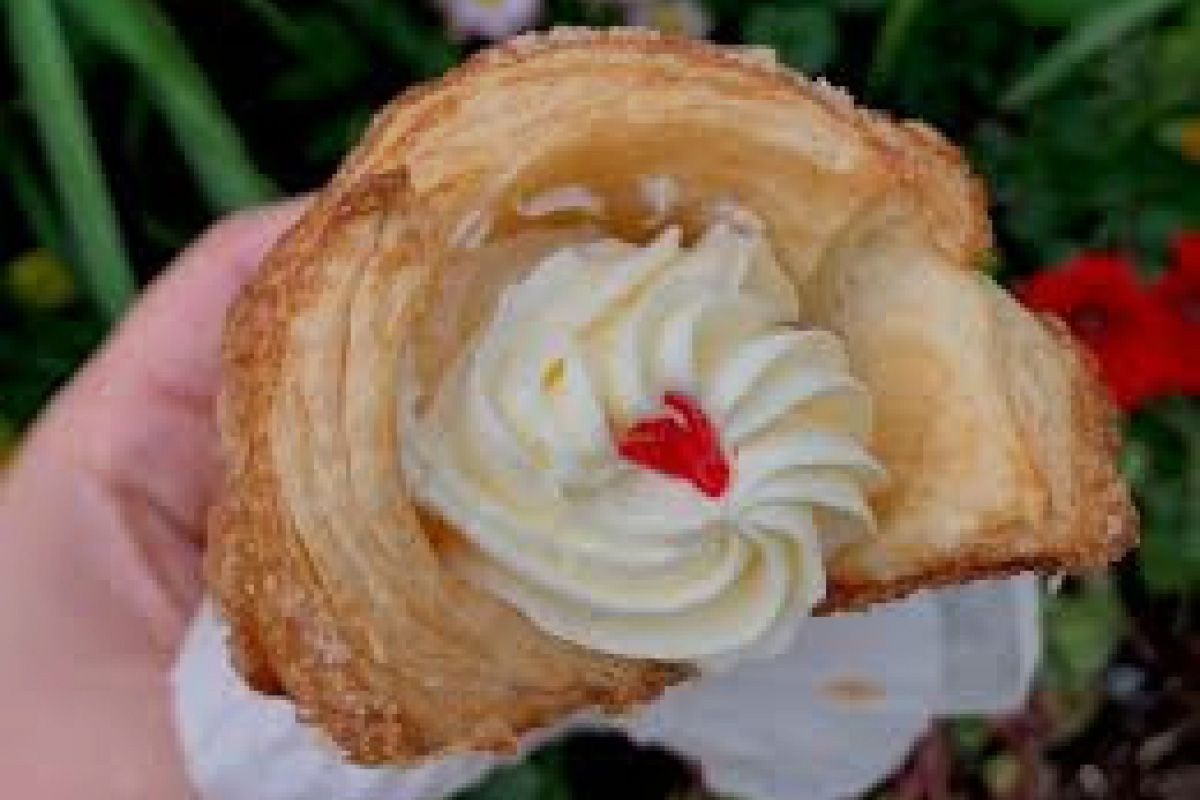 a pastry with white frosting and a red heart