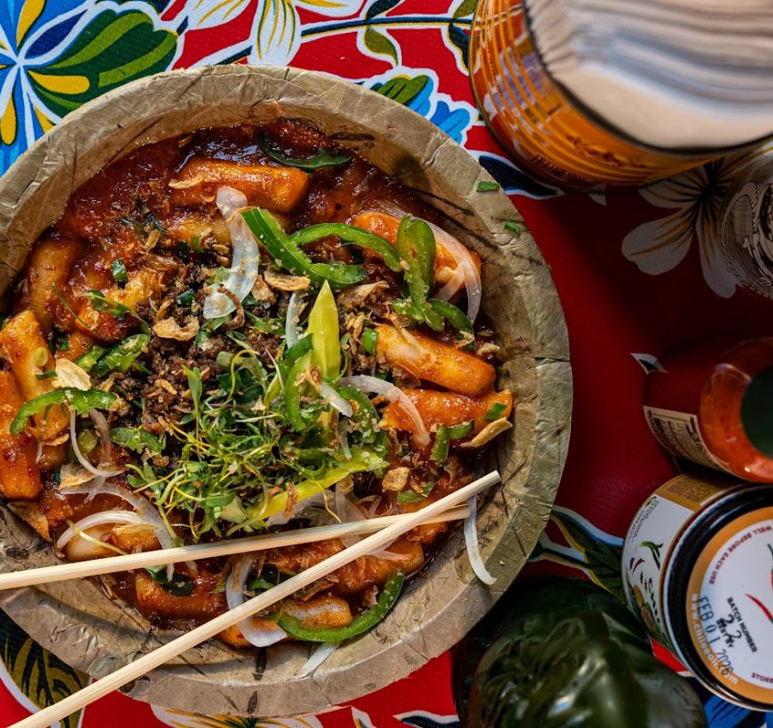 Vibrant food served on a round, earthy paper dish.