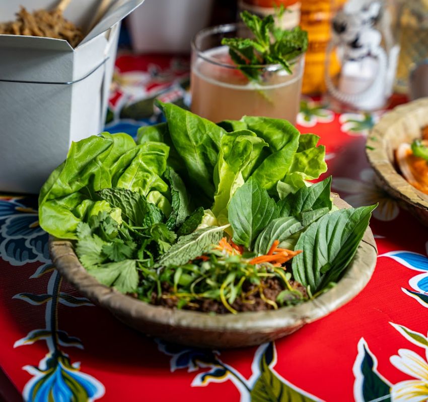 Plate of fresh greens for wrapping, including vibrant leaves