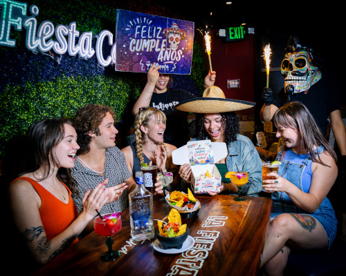 Guests celebrating a birthday with a cake at La Fiesta Cantina