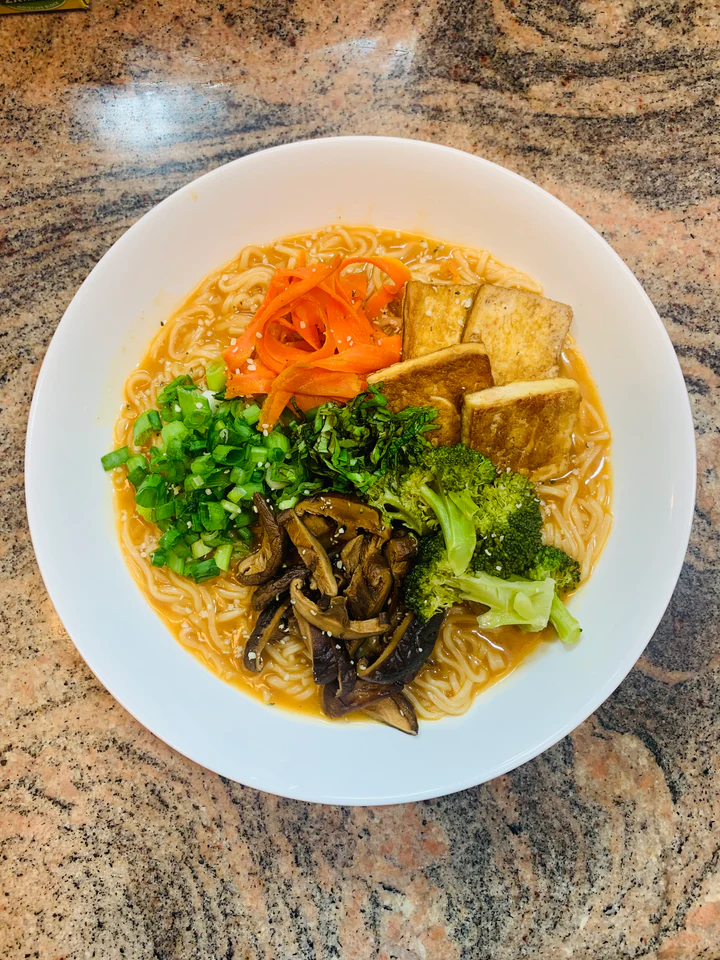A bowl of vegan ramen with miso broth, filled with noodles and vegetables.