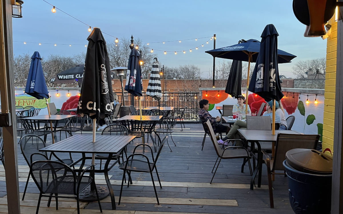  Outdoor dining area with wooden tables and chairs on a deck