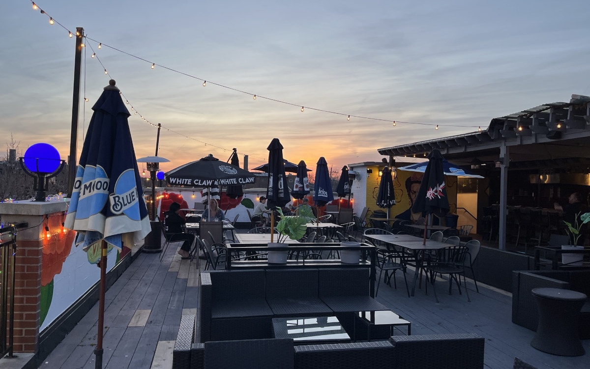 Patio at sunset with umbrellas and tables, creating a cozy atmosphere for outdoor dining