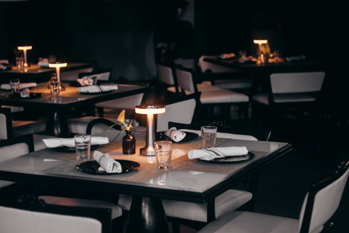 Elegant white chairs placed around a table with a glowing candle