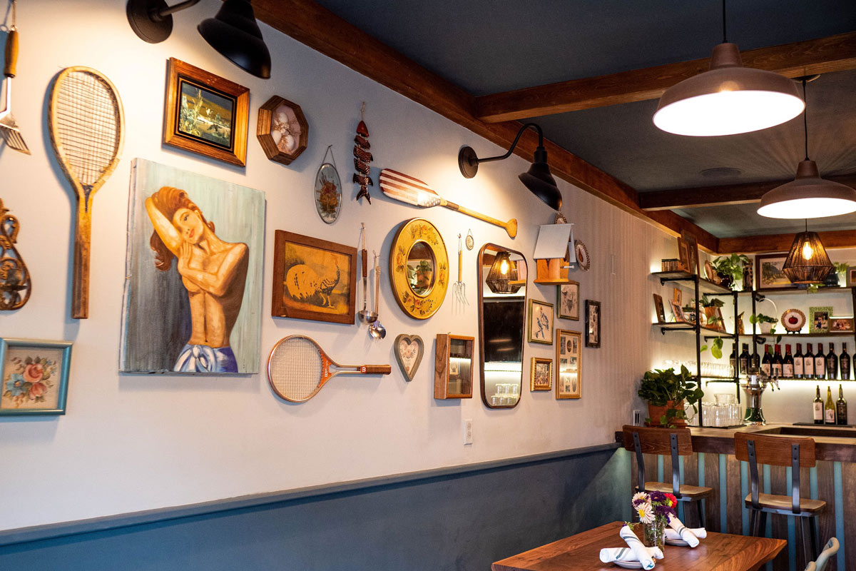 Bar area, wall decorated with paintings and various vintage objects