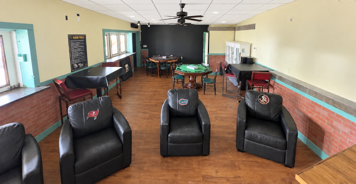 The Social Club lounge with armchairs, game tables and a poker rules board