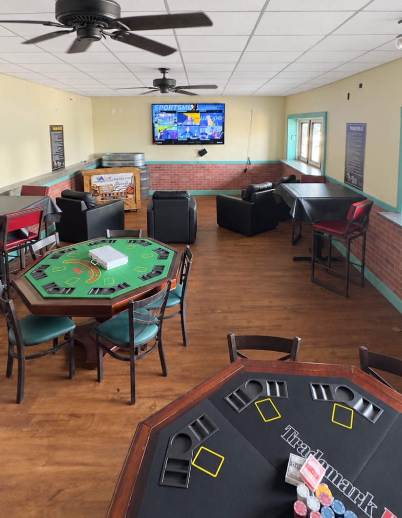 Private poker room with card tables and a wall-mounted screen