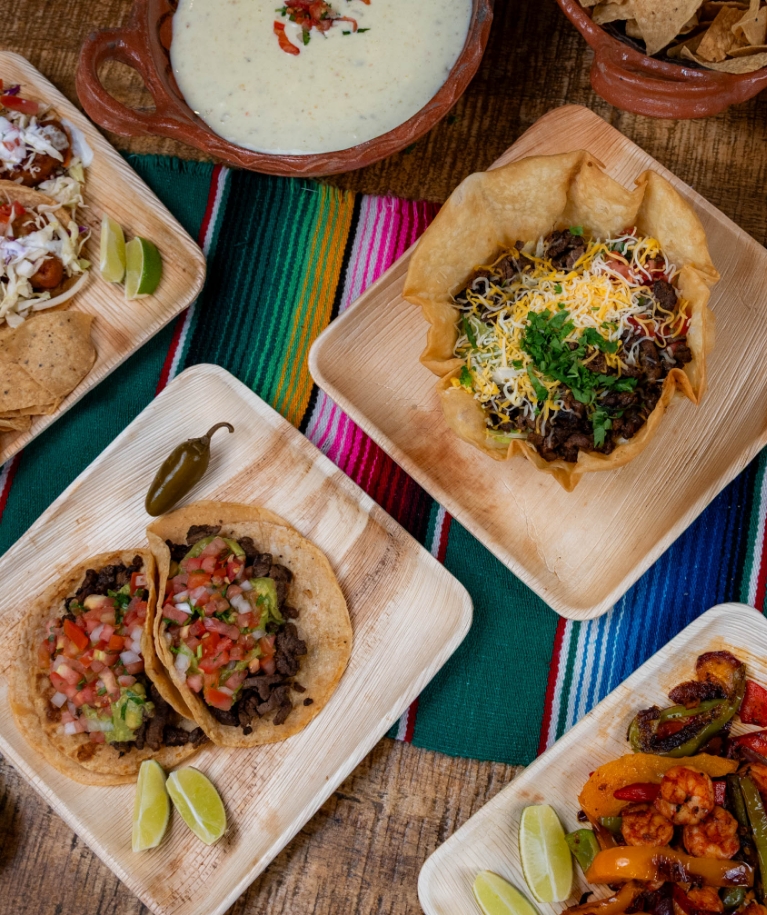 Food trays with tacos, taco salad, queso and shrimp fajitas