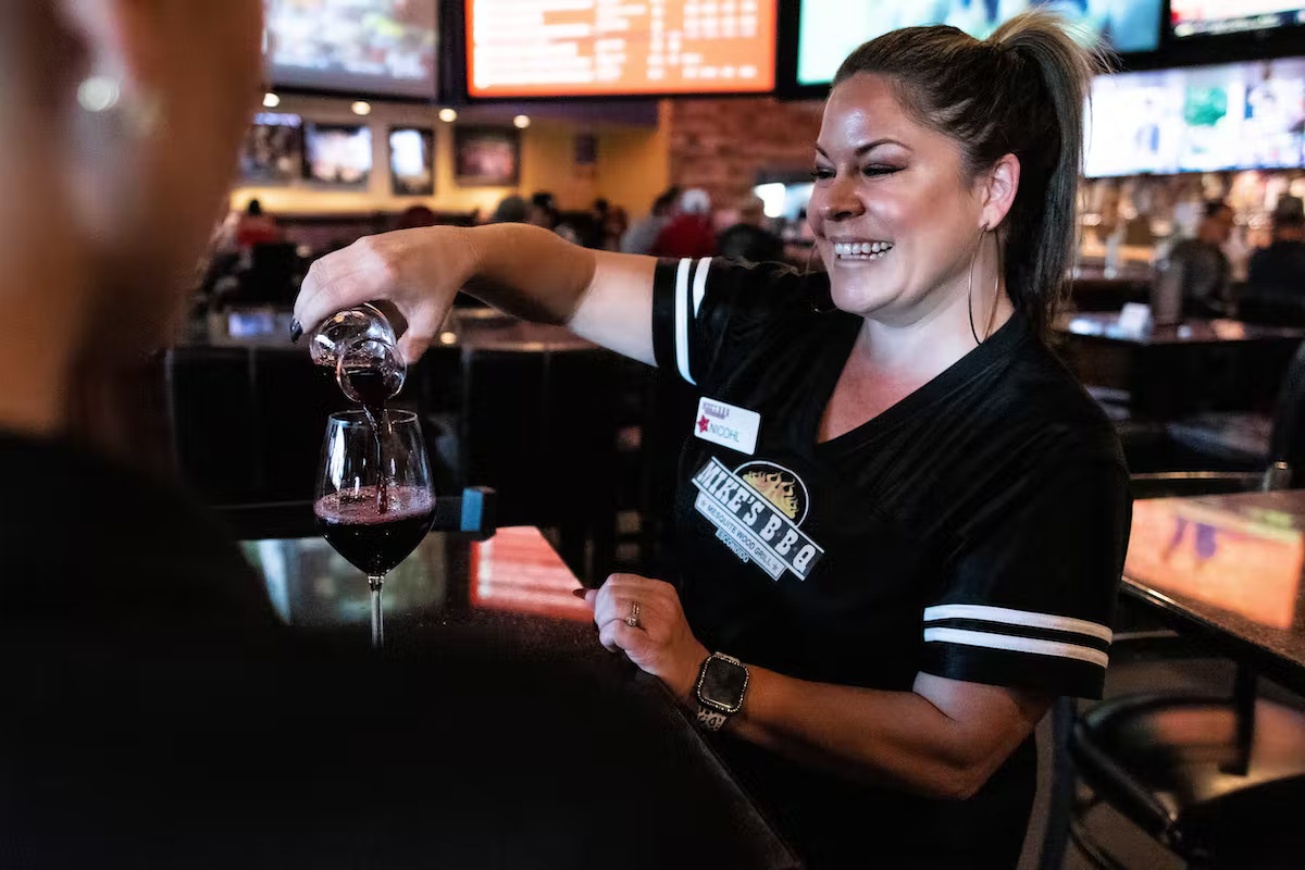 a bartender holding a glass of wine
