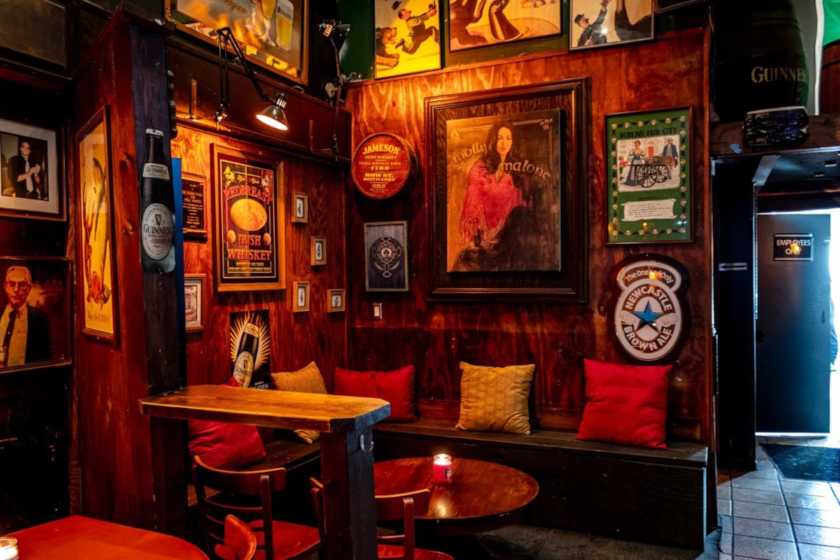 Pub corner with framed pictures and a booth.