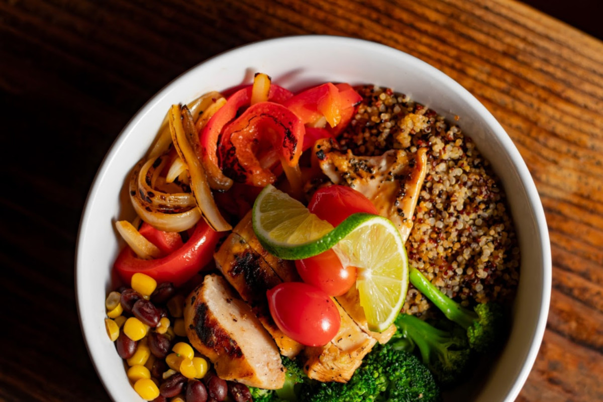 Close-up of a bowl with quinoa, vegetables, and chicken.