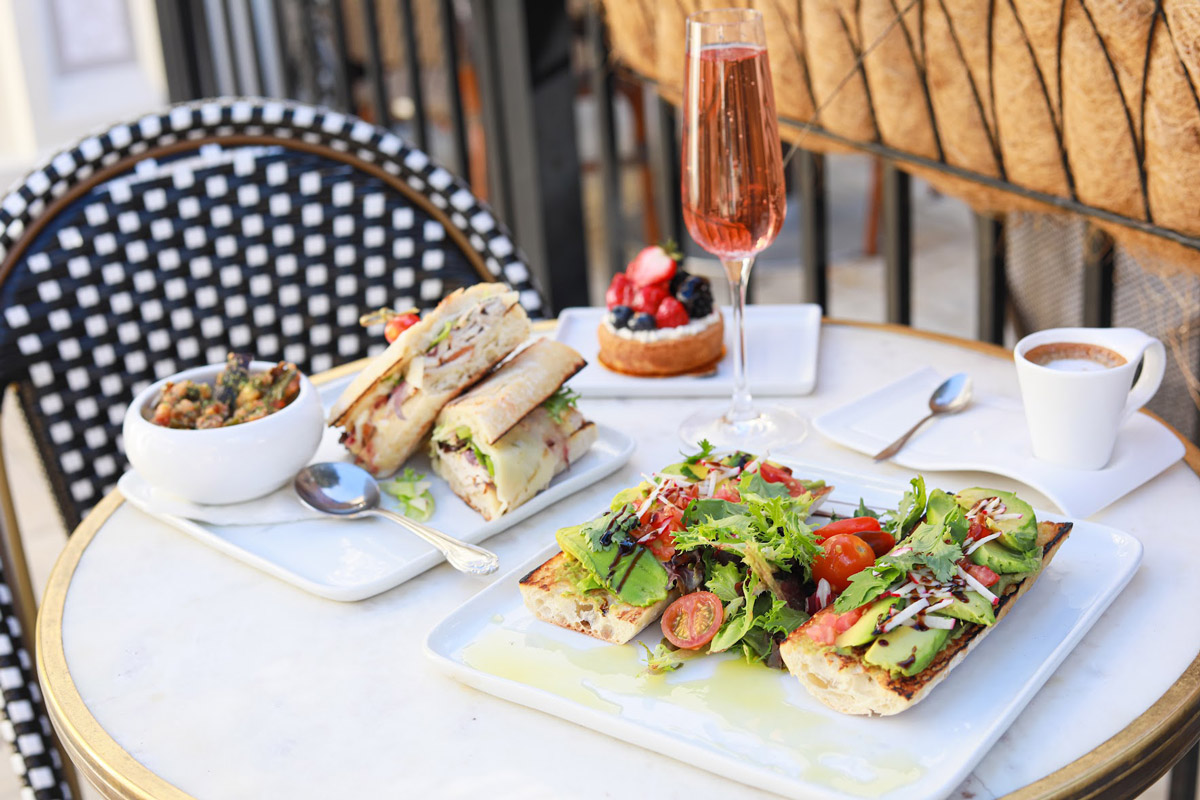 Sandwiches and tart served with drinks on a table in the patio
