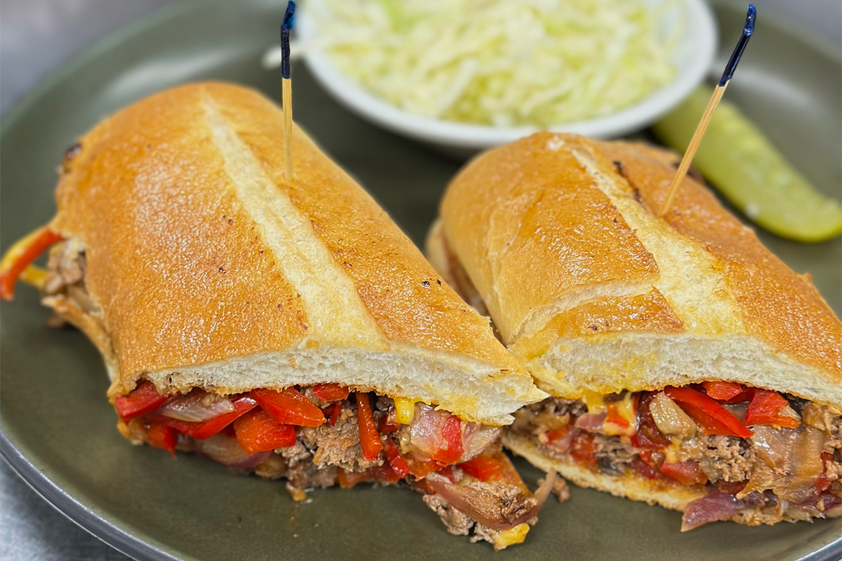 Philly Cheese Steak Sandwich served with salad an d a pickle