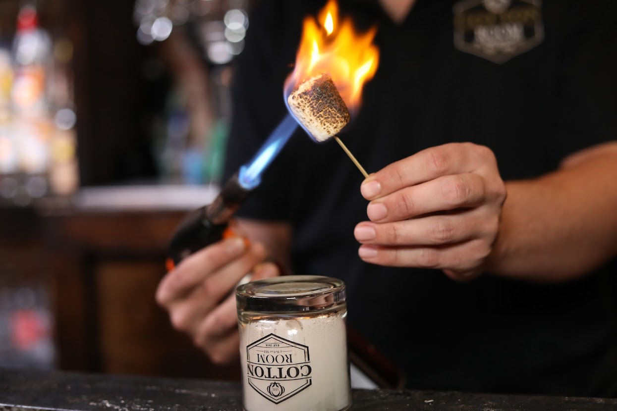 Bartender burning marshmallow for a cocktail