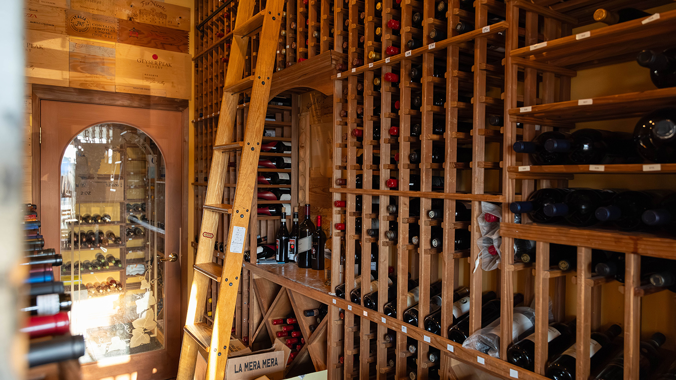 Wine cellar with floor-to-ceiling wooden racks and rolling ladder