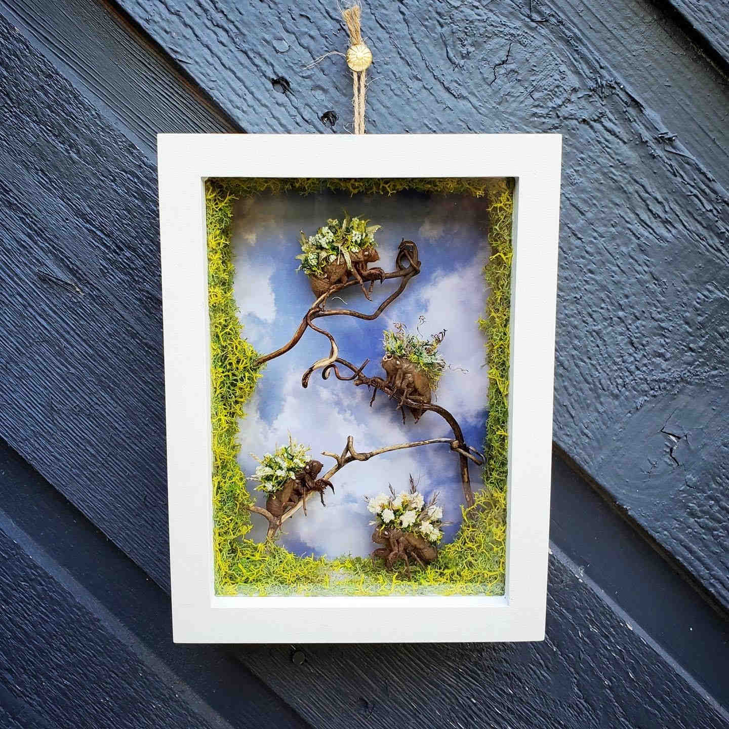 White frame with plants and flowers on a wall