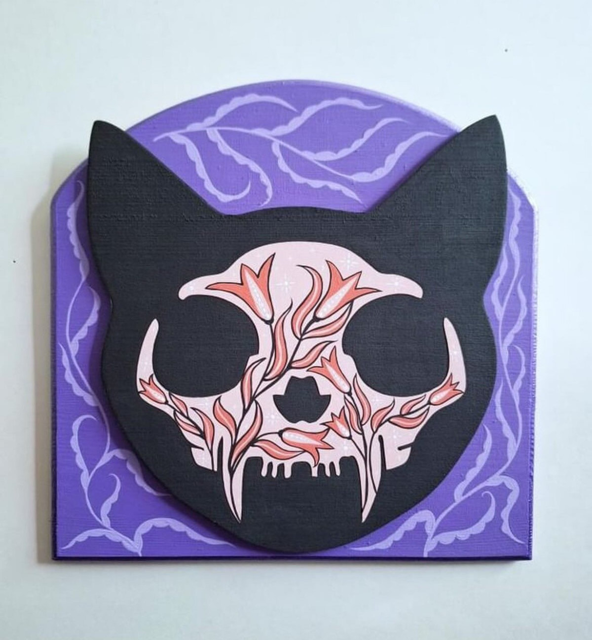 A black cat skull on a purple background