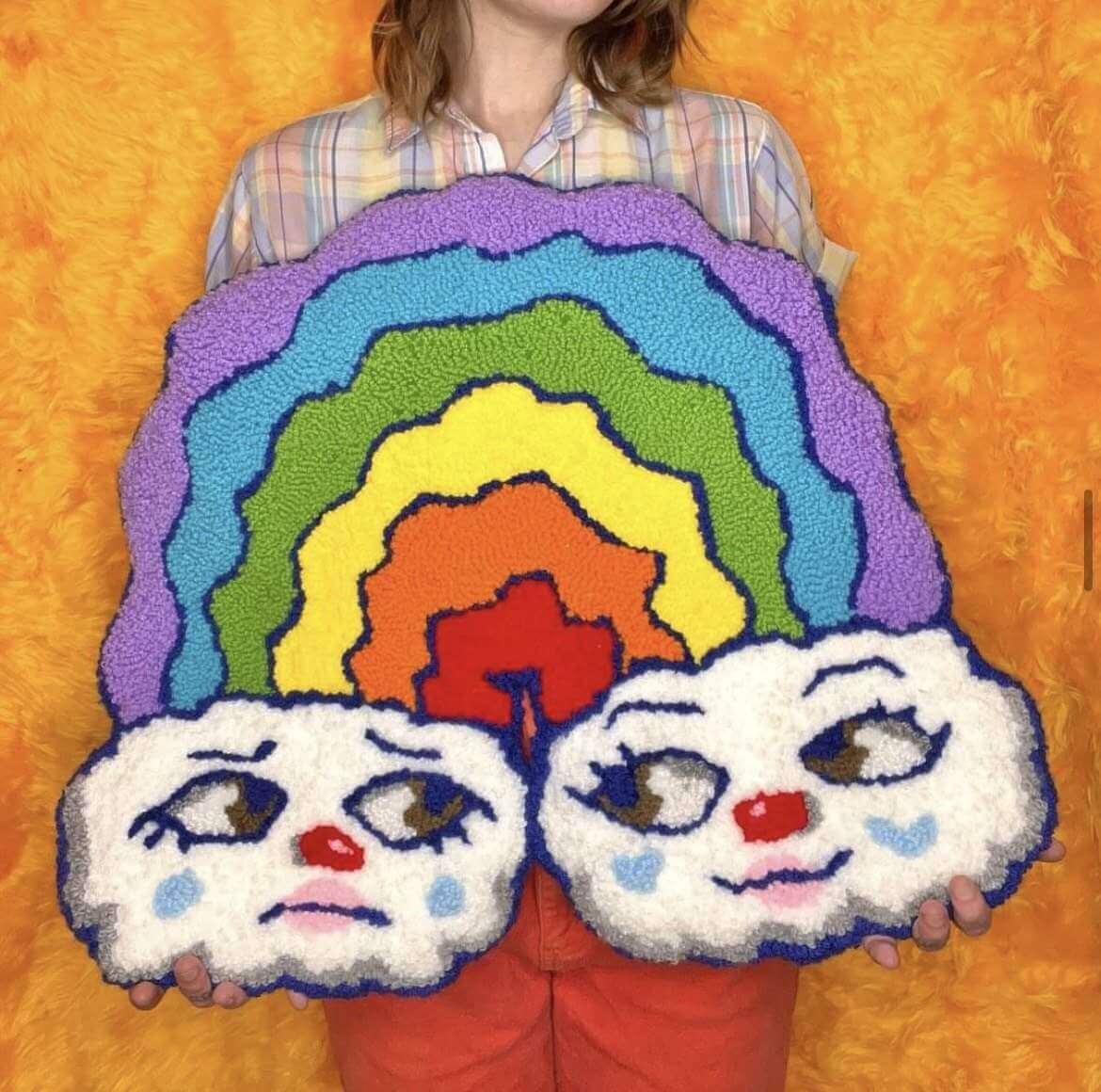 Artist holding a photo resembling clouds and rainbows